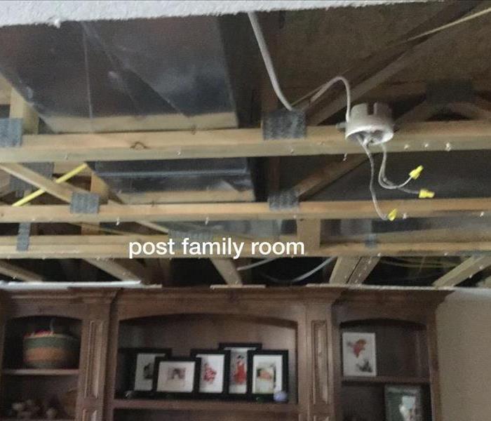 a living room without the sheetrock on the ceiling due to mold damage in attic