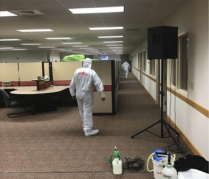 SERVPRO employee dressed in proper PPE cleaning a commercial office for proactive measures